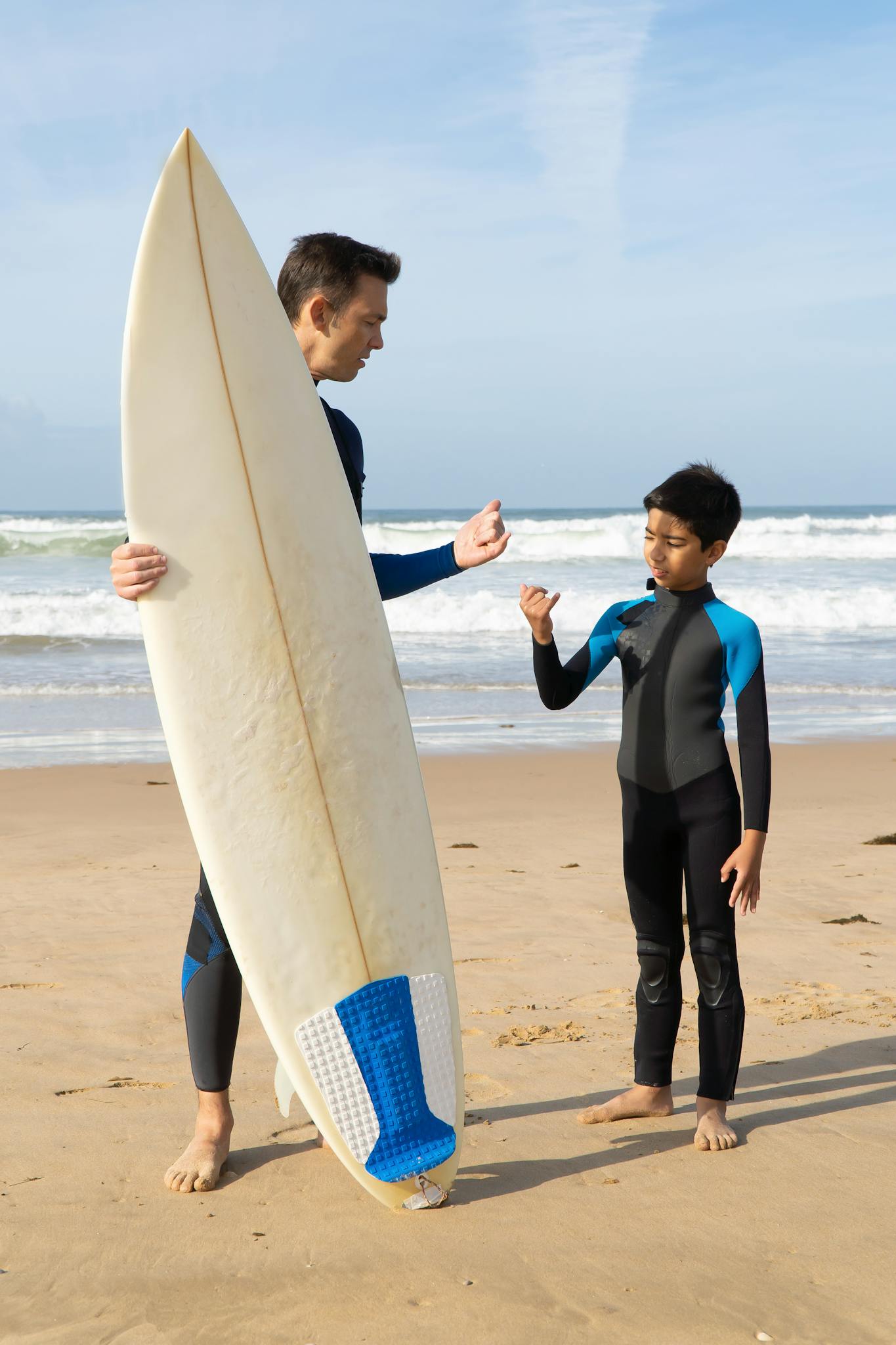 A father teaches his son how to surf on a scenic Portuguese beach.