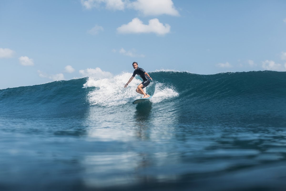 Env male surfer riding wave
